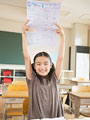 答案用紙を見せる小学生の少女