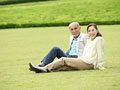 芝生に座るシニア夫婦