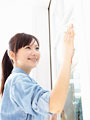 窓を拭く若い女性