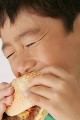 ハンバーガーを食べる少年