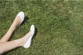 芝生に寝転ぶ女性の足