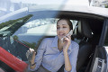 車に乗って携帯電話で話す女性