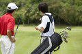 日本人男性ゴルファーとキャディー