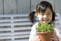 笑顔で植木鉢を持つ女の子