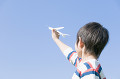 紙飛行機を持つ男の子