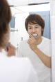 鏡を見て歯を磨く男性