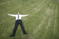 芝生の上に寝転がるビジネスマン