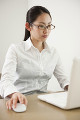 ノートPCを使い仕事をしている眼鏡の女性