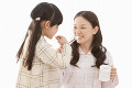 娘に歯磨きを教える母親