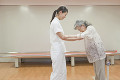 リハビリ施設でシニア女性の介助をする女性介護士