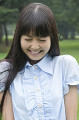 公園で笑顔で目をつぶる若い女性