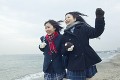 砂浜を走る2人の女子高校生