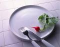 白い皿の上のラディッシュとナイフとフォーク