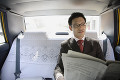車内で新聞を読むビジネスマン