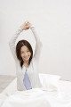 ベッドで伸びをする日本人女性