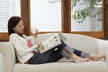 ソファーに座って雑誌を読む日本人女性