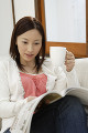 ソファーに座って雑誌を読む日本人女性