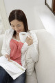 ソファーに座って雑誌を読む日本人女性