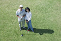 ゴルフをするシニア夫婦