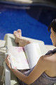 プールサイドで読書をする日本人女性
