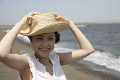 海と麦わら帽子を被った日本人女性