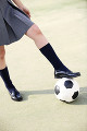 サッカーボールを止める女子高校生の足
