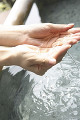 温泉のお湯をすくう女性の手