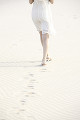 砂浜を歩く女性の足元