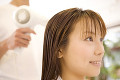 ヘアサロンで髪を乾かす女性