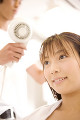 ヘアサロンで髪を乾かす女性