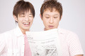 新聞を見る男性2人