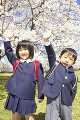 桜の前に立つ小学生男女