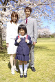 桜の前に立つ小学生女子とその両親