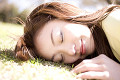 芝生の上で眠る女性