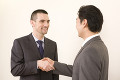 握手する日本人ビジネスマンとアメリカ人ビジネスマン