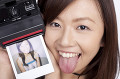 ポラロイドカメラを持って舌を出す女性