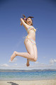 砂浜でジャンプする水着姿の女性