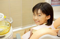 歯医者のリクライニングチェアに座って振り返る女の子