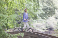 自転車を押しながら橋を渡る女性