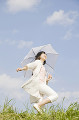 日傘を差してスキップする女性