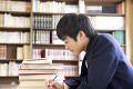 図書室で勉強する男子中学生