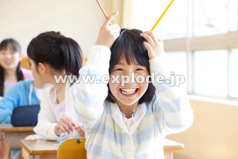 鉛筆で角を作って笑う小学生女子
