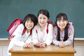 黒板の前で微笑む小学生女子3人
