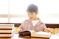 図書室で本を読む小学生男子