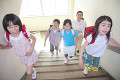 階段を上る小学生4人と女性教師