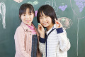黒板に落書きをする小学生女子2人