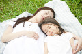 草原で寝る女性と女の子