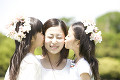 若い女性の頬にキスをする2人の女の子