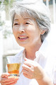 紅茶を飲みながら微笑むシニア女性