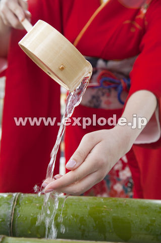 手を水で清める振袖姿の女性の手元